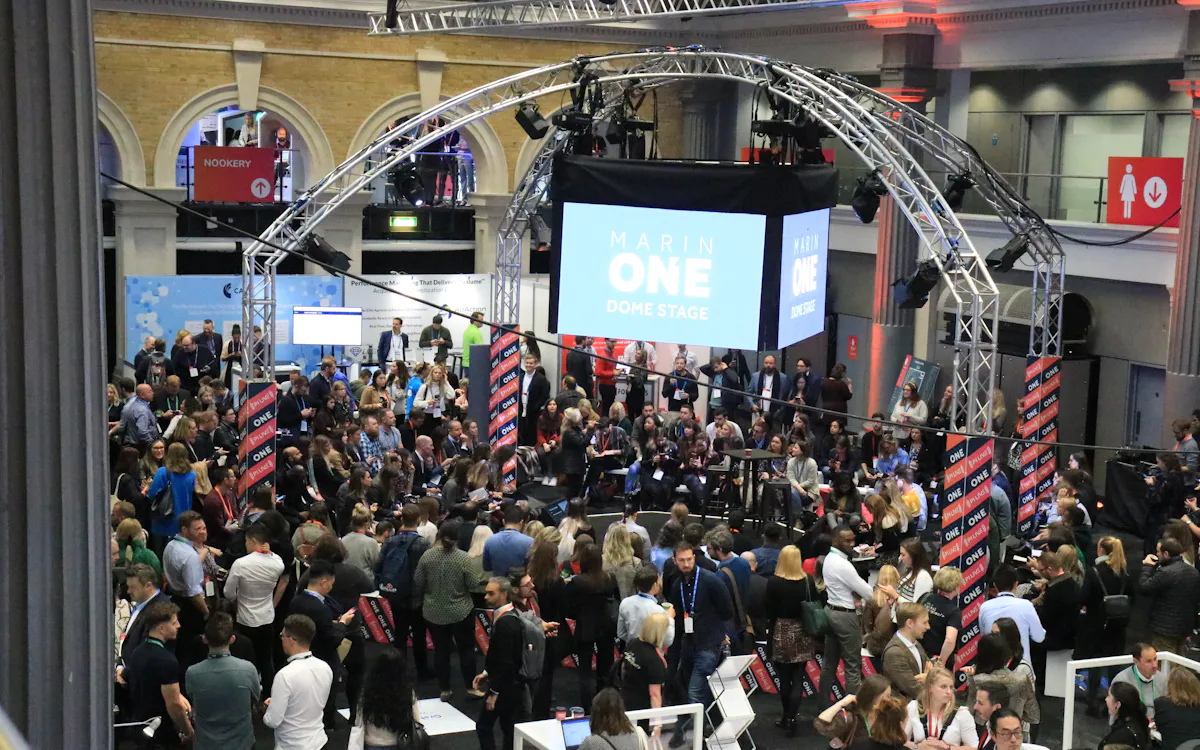 Multitud de visitantes frente a un escenario con estructura de truss en una feria