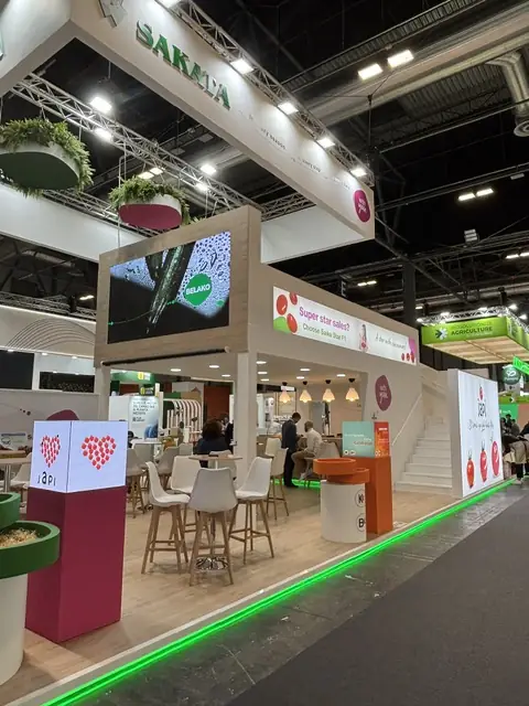 Stand de Sakata de doble altura con pantalla LED, jardineras colgantes y zona de reuniones